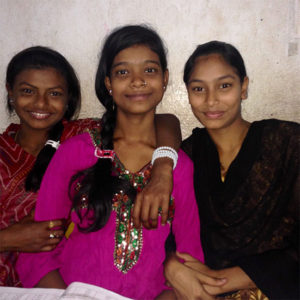 Three young indian girls smiling at camera
