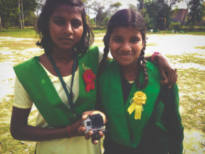 Two Young Indian girls holding goPro facing camera.