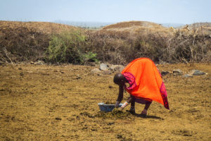 kenyan woman beginning to prepare hut