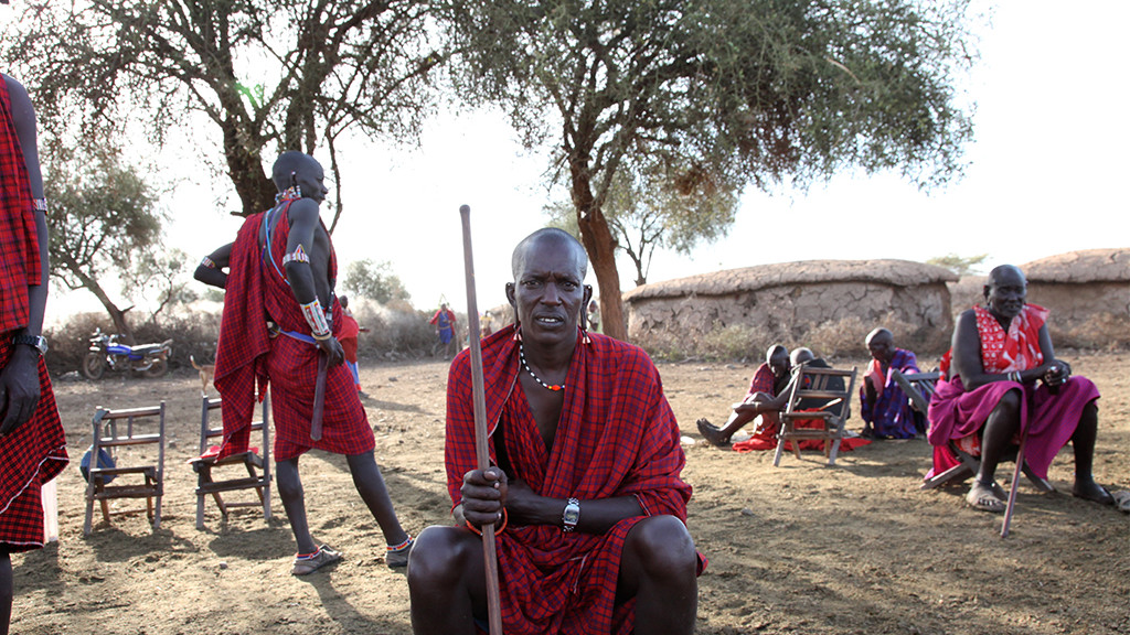 Kenyan man sitting and holding stick