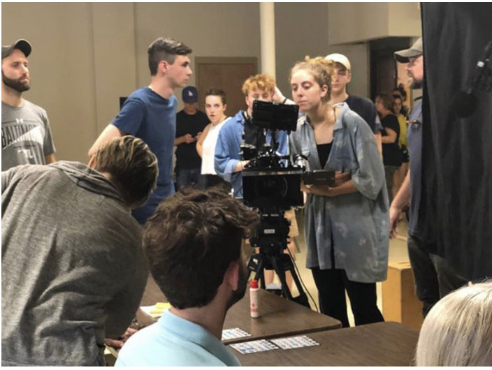 Sienna Twiss looking through a camera on a production day